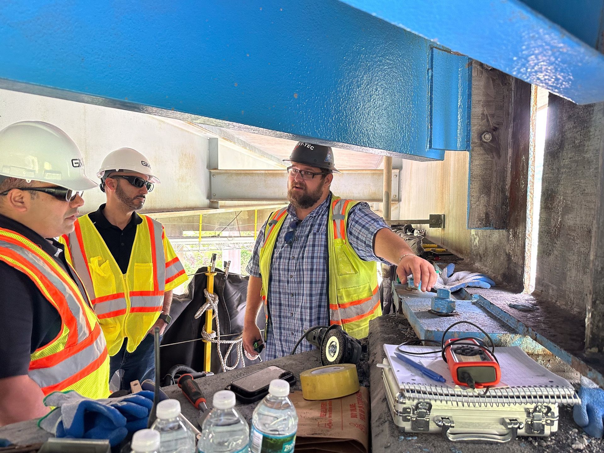 A group of construction workers are standing around a table.