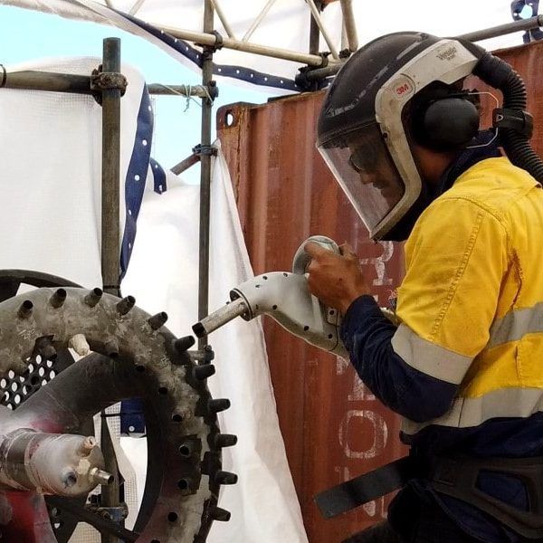 A man wearing a helmet is working on a machine