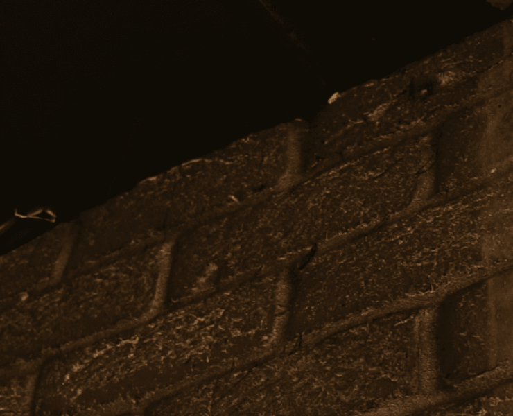 A close up of a tire track on a brick wall.