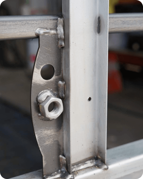A close up of a metal fence with a nut on it.