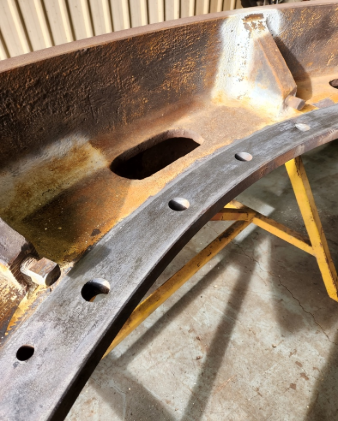 A piece of metal with holes in it is sitting on a yellow table.