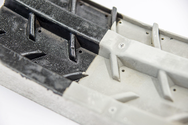 A close up of a black and white piece of plastic on a white surface.