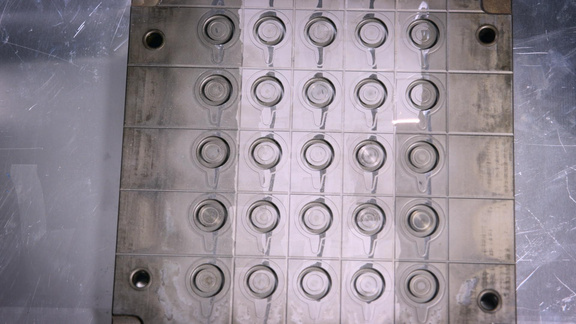 A close up of a metal mould with holes in it.