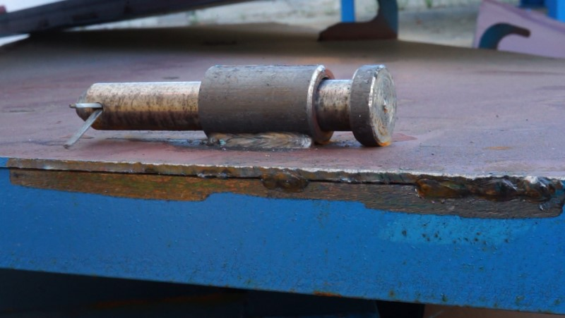 A rusty piece of metal is sitting on top of a blue table.