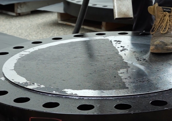 A close up of a metal flange with holes in it