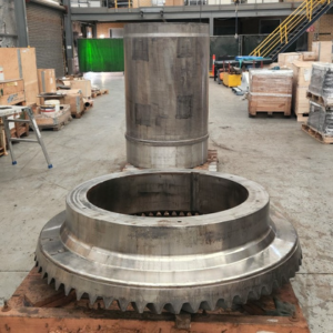 A large metal object is sitting on a brick floor in a warehouse