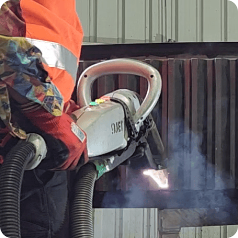 A man is welding a piece of metal with a machine.