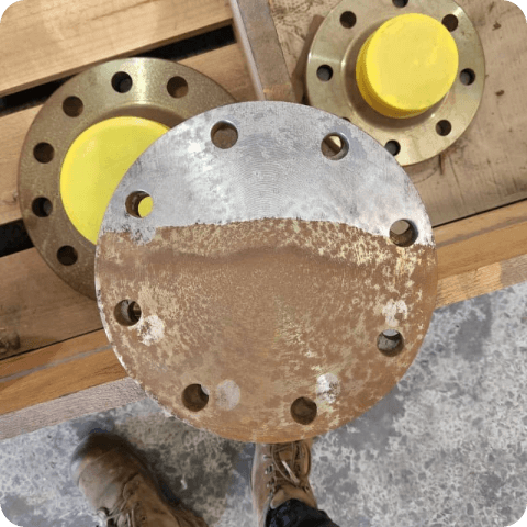 A rusty flange with a yellow cap on it
