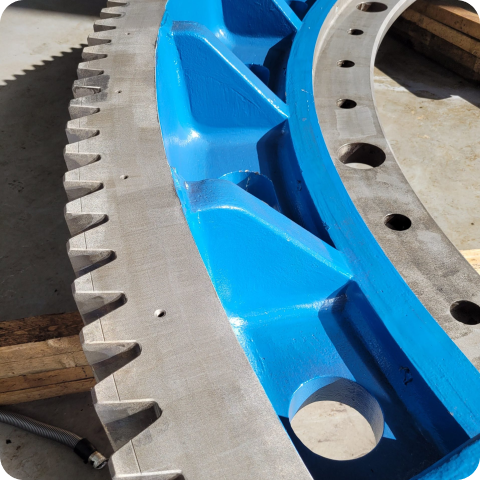 A close up of a blue gear with holes in it