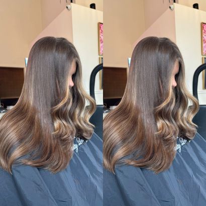 A woman with long brown hair is sitting in a chair