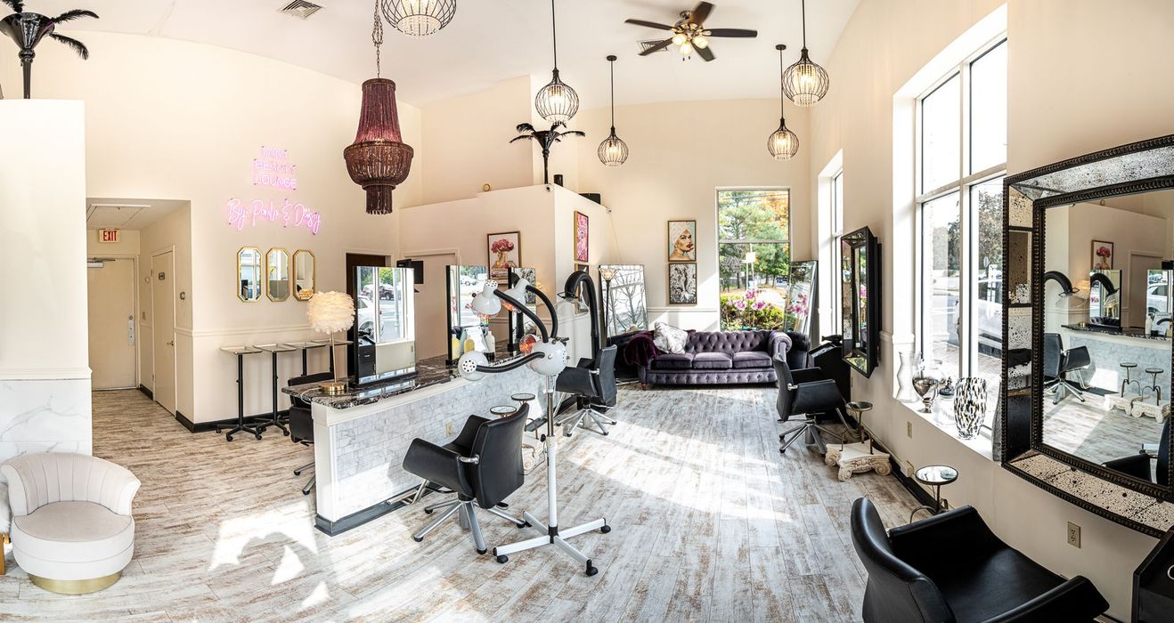 A large salon with a lot of chairs and mirrors.