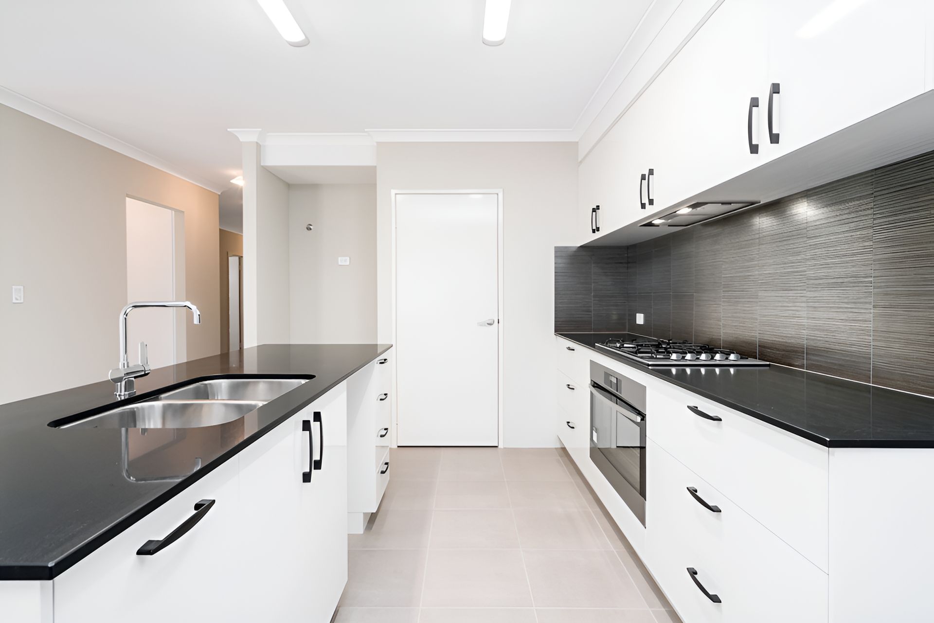 A Large Kitchen Space with black counter top — Tefa Kitchens & Joinery in Rutherford, NSW
