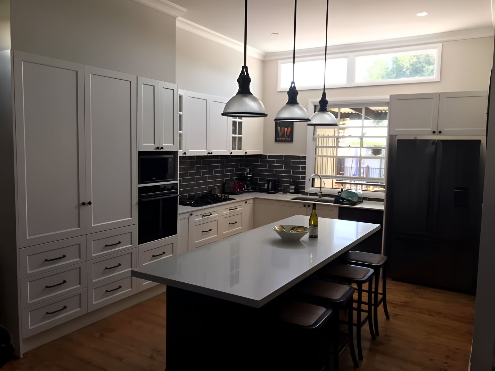 A Kitchen With White Cabinets and a Large Island in the Middle — Tefa Kitchens & Joinery in Rutherford, NSW