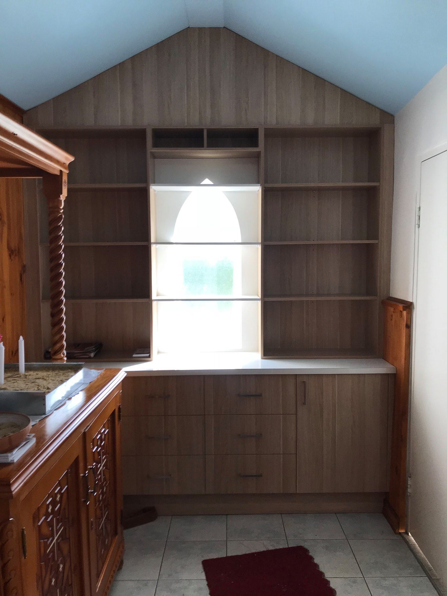 A Kitchen With Wooden Cabinets and Shelves and a Window — Tefa Kitchens & Joinery in Rutherford, NSW
