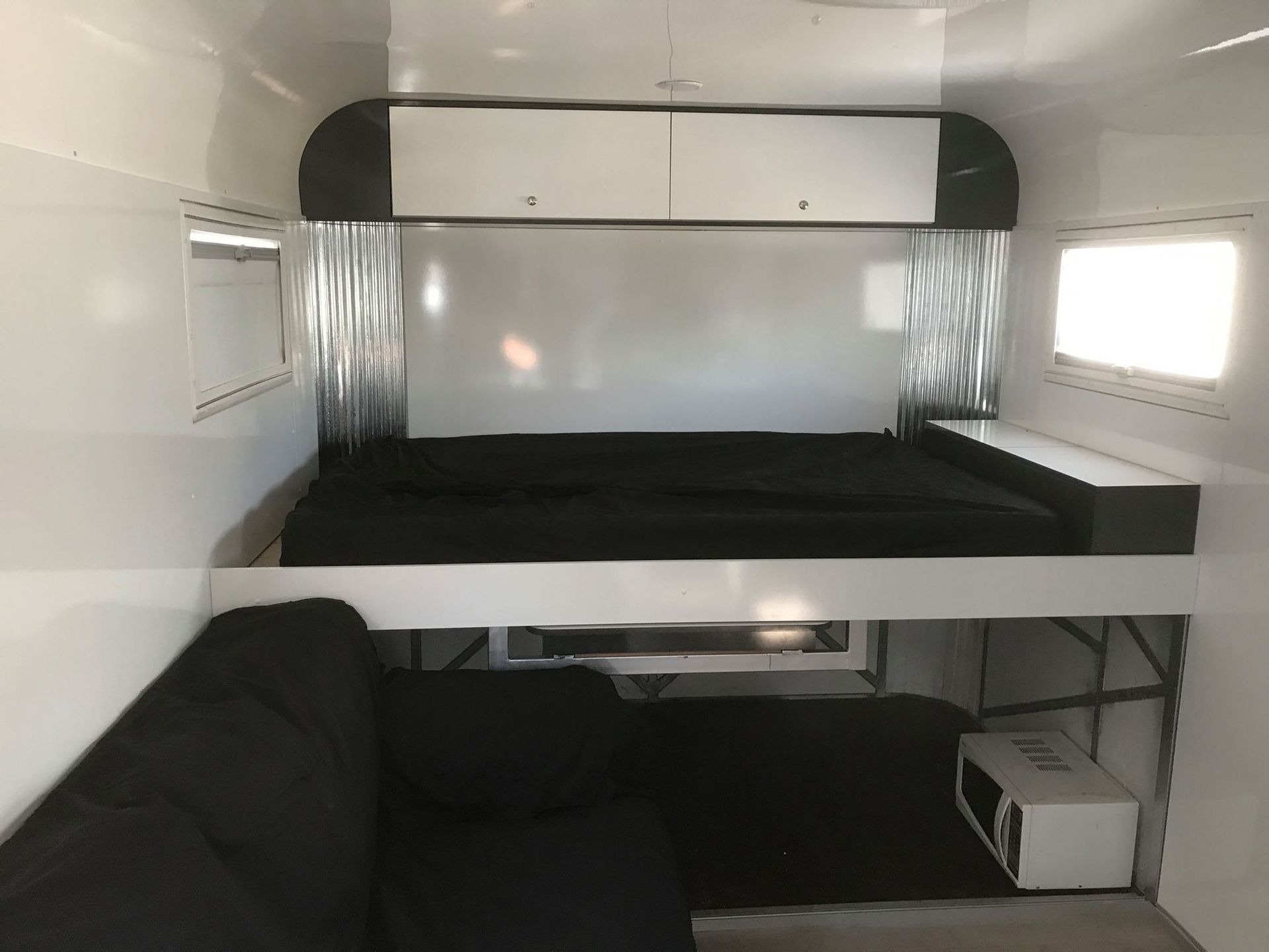 A Camper With a Bed and a Couch in It — Tefa Kitchens & Joinery in Rutherford, NSW