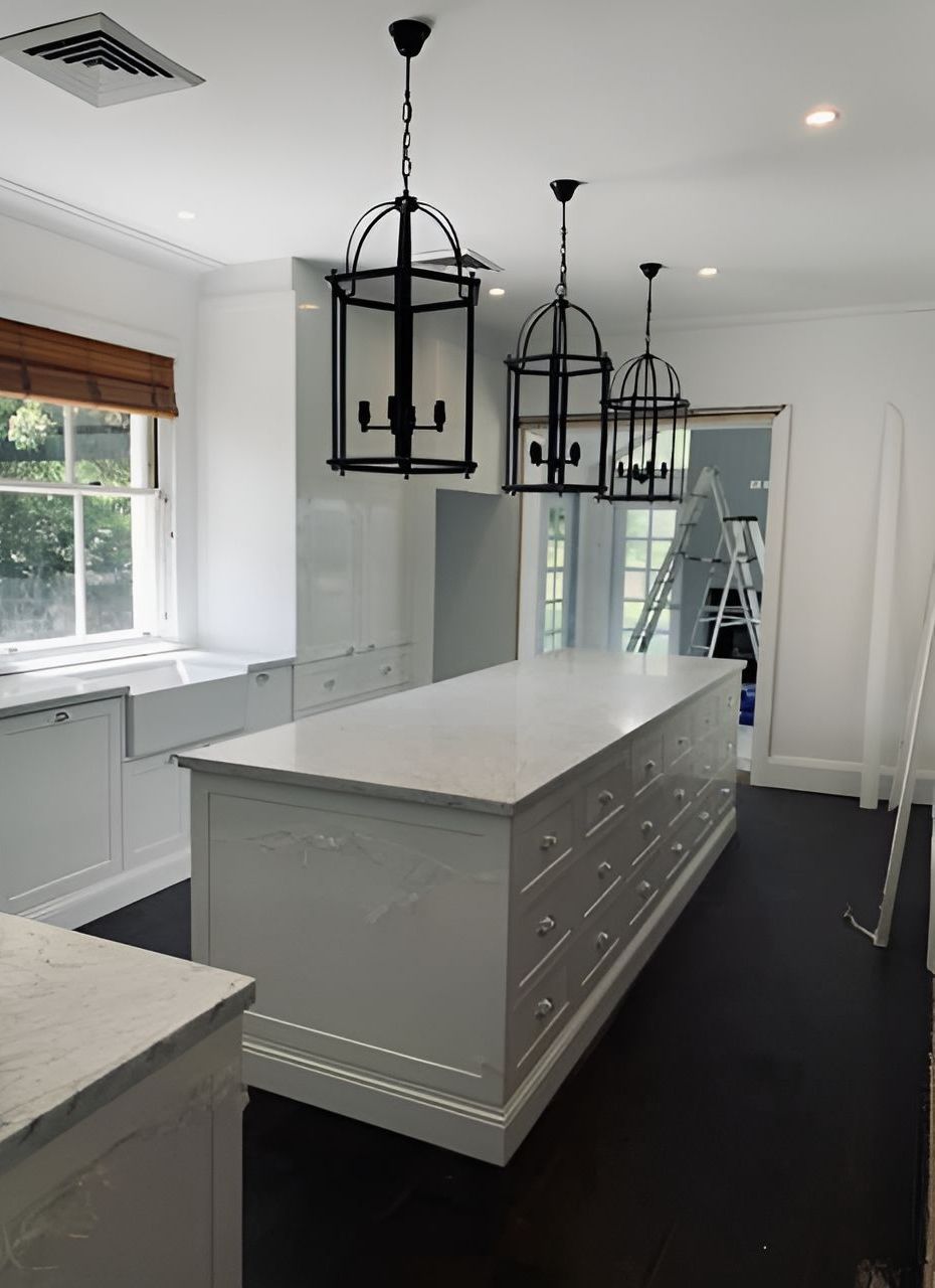 A newly renovated white kitchen space with hanging lights — Tefa Kitchens & Joinery in Cessnock, NSW