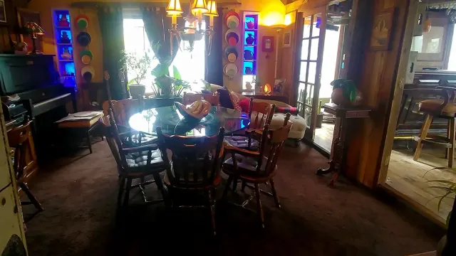 A large dining room with a table and chairs and a piano.