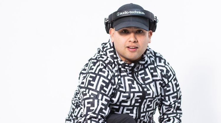Persona que lleva auriculares y una chaqueta con capucha de Fendi sobre un fondo blanco.