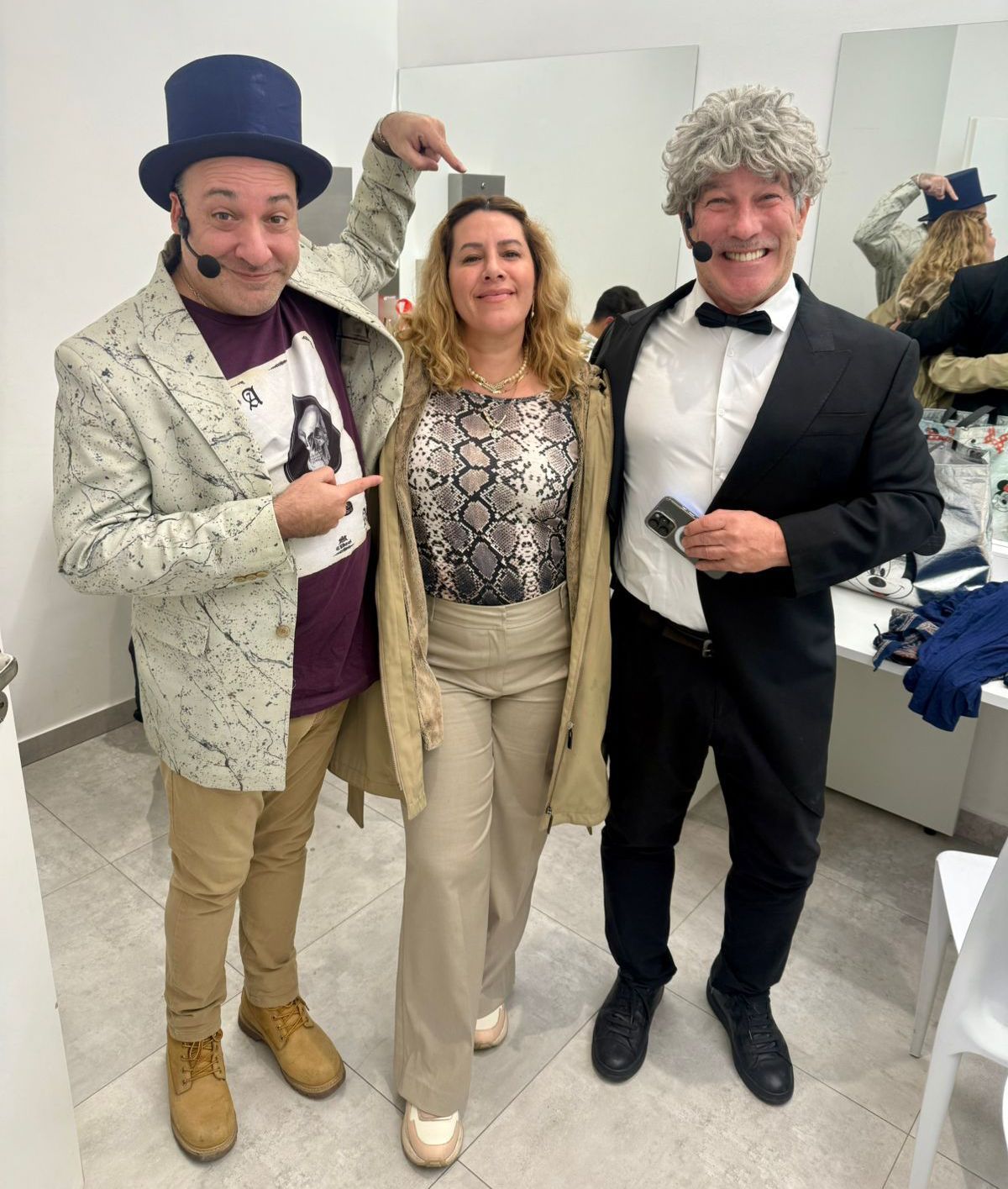Tres personas disfrazadas posando, dos hombres y una mujer. Escenario.