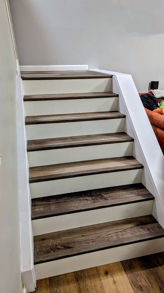 Wooden stairs with white risers and trim; interior setting.