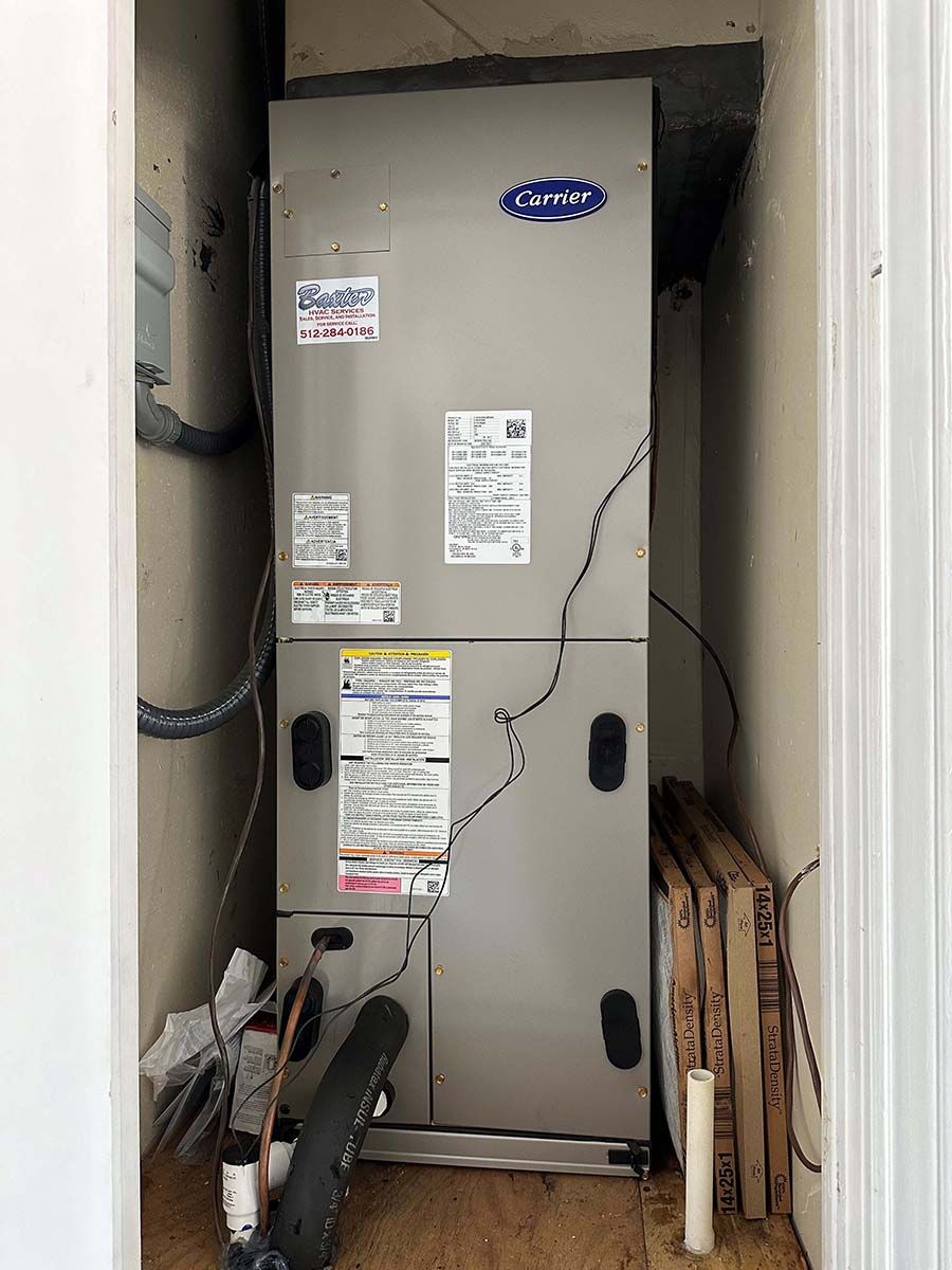 A carrier air conditioner is sitting in a corner of a room.
