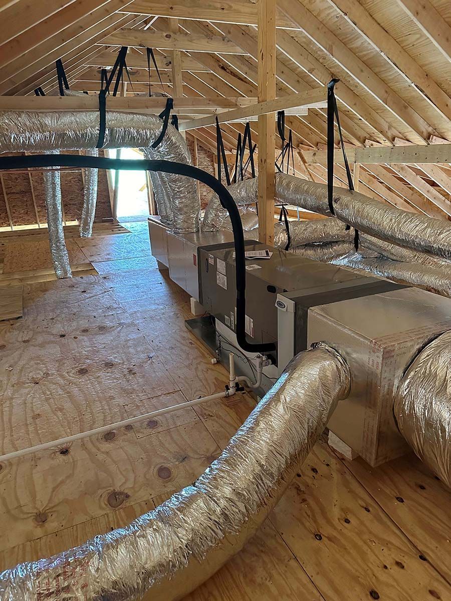 There are a lot of ducts in the attic of a house.
