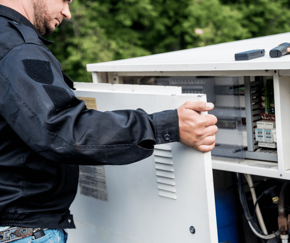 A man in a black jacket is working on an electrical box.