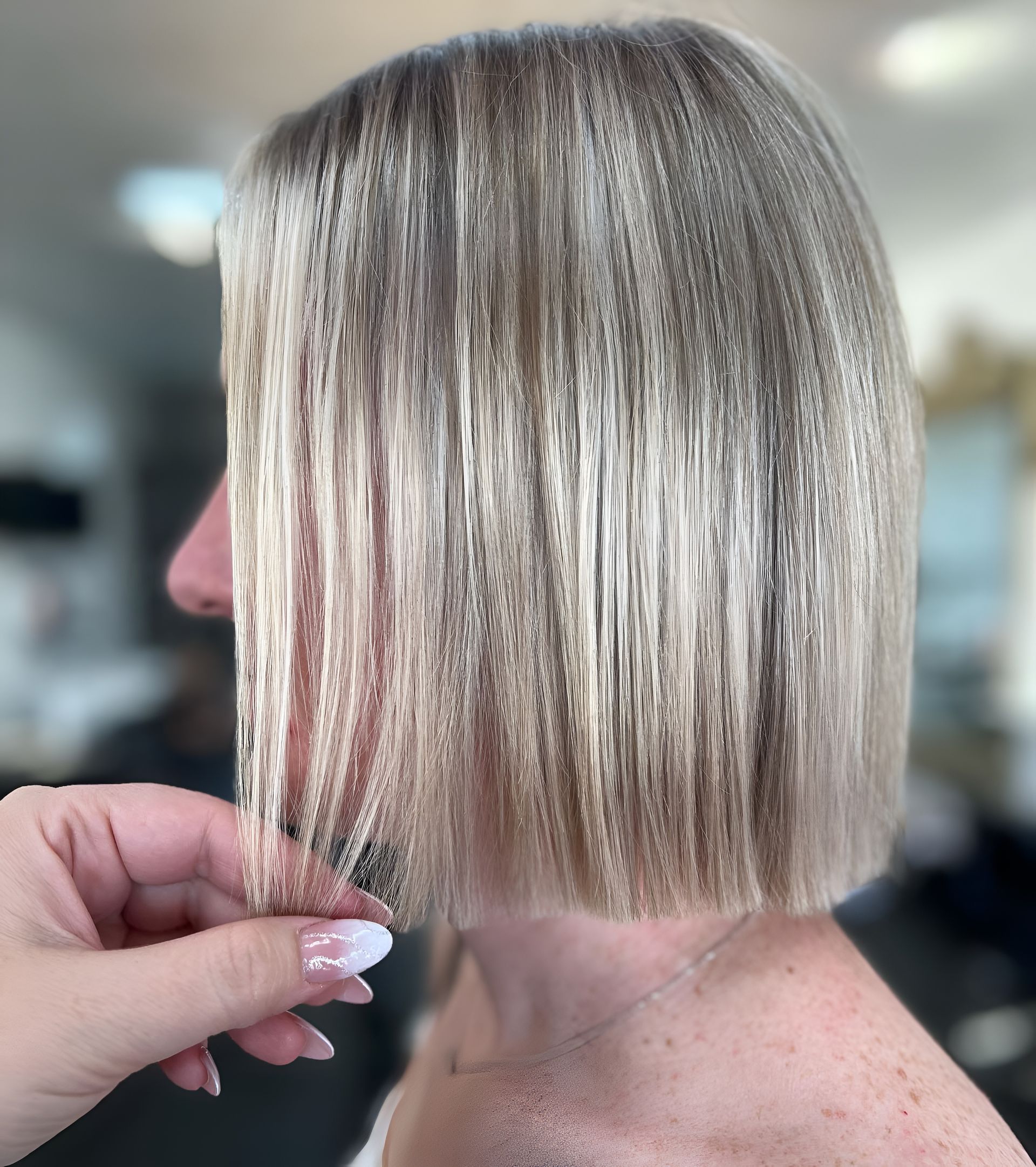 Woman's Blonde Bob Haircut, Held by Hand, in Salon Setting — 5th Ave Hair Lounge in Caloundra, QLD