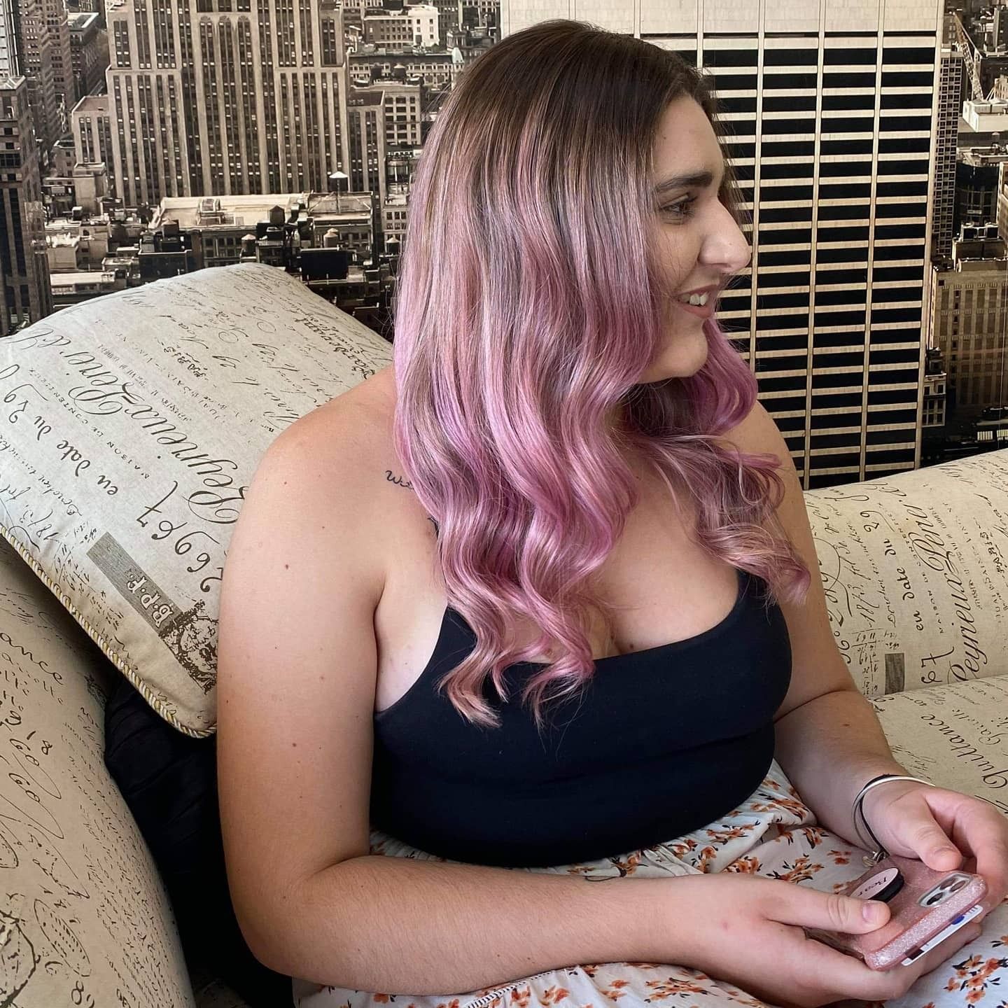 Woman With Pink Hair Smiles, Sitting on a Couch — 5th Ave Hair Lounge in Caloundra, QLD