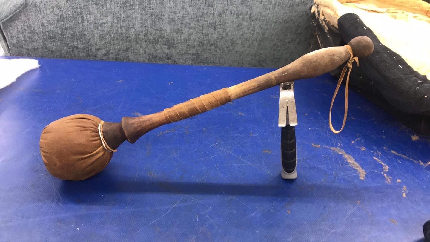 A wooden stick with a ball attached to it is on a blue surface