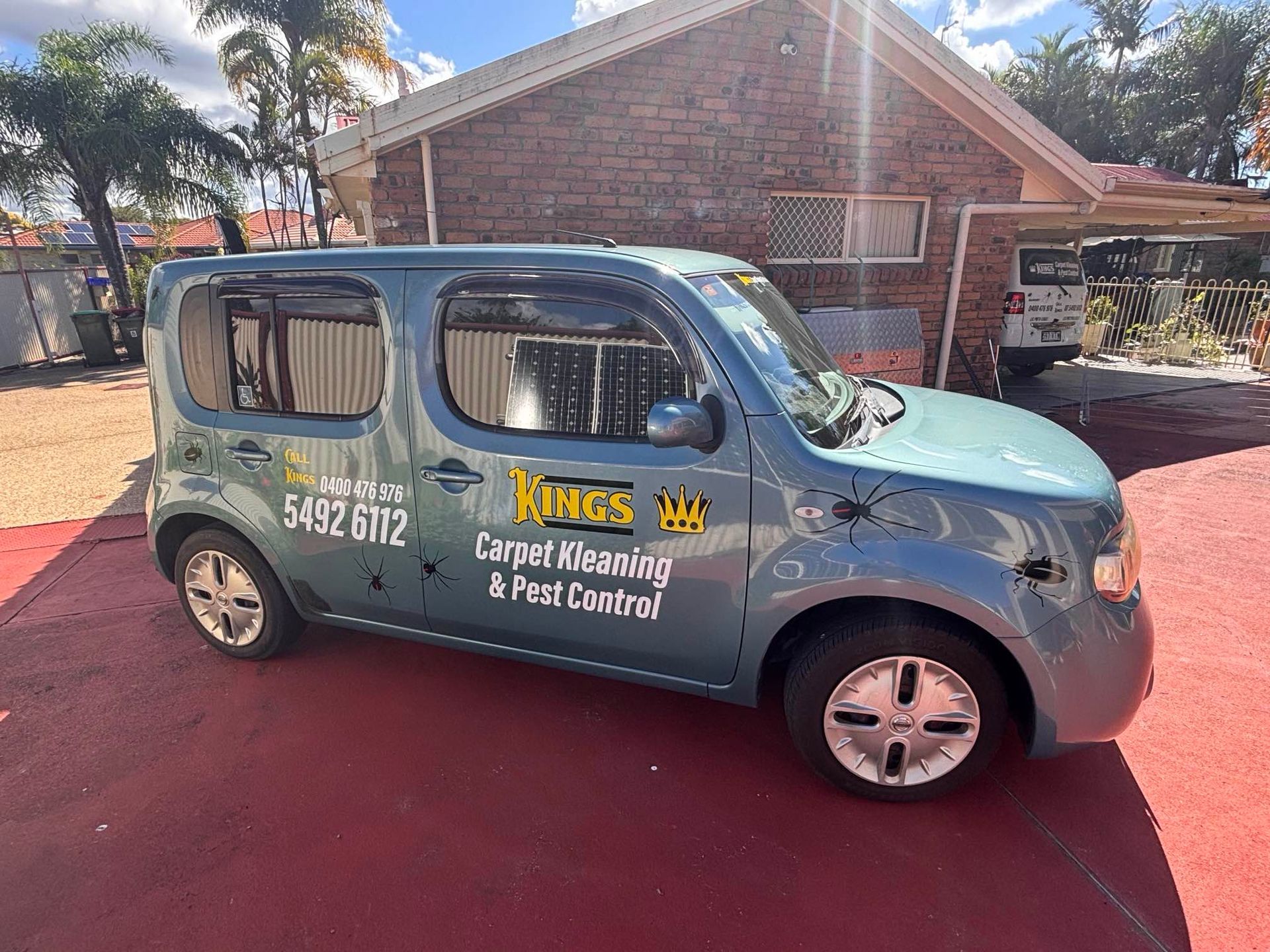 A Blue Van is Parked in Front of a Brick House — King’s John Carpet Kleaning & Pest Control Service In Kawana Waters, QLD