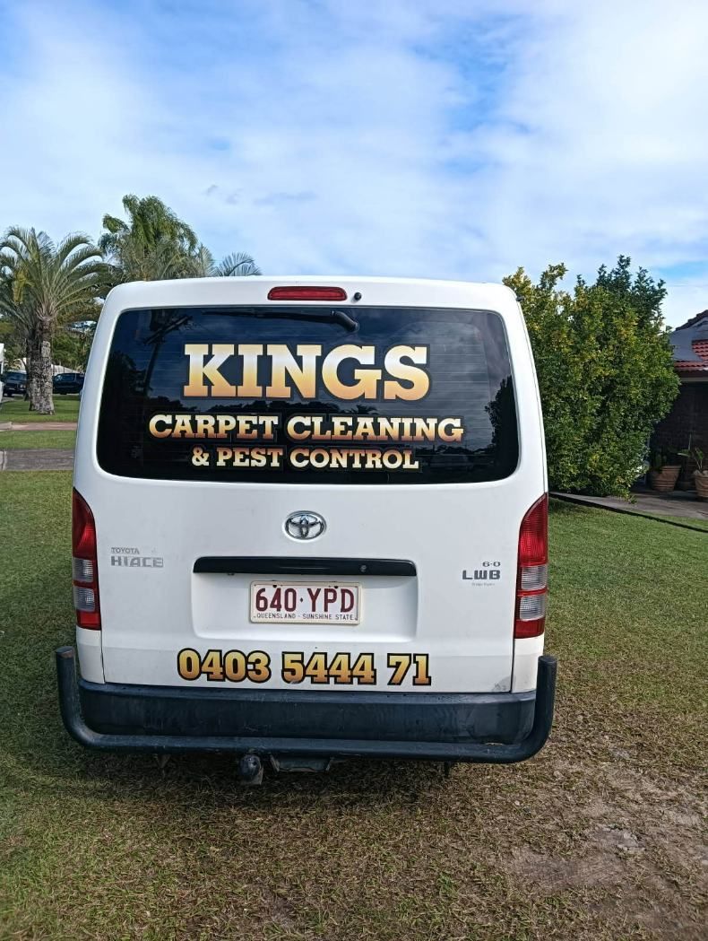 The Back of a White Van is Parked in a Grassy Field — King’s John Carpet Kleaning & Pest Control Service In Currimundi, QLD