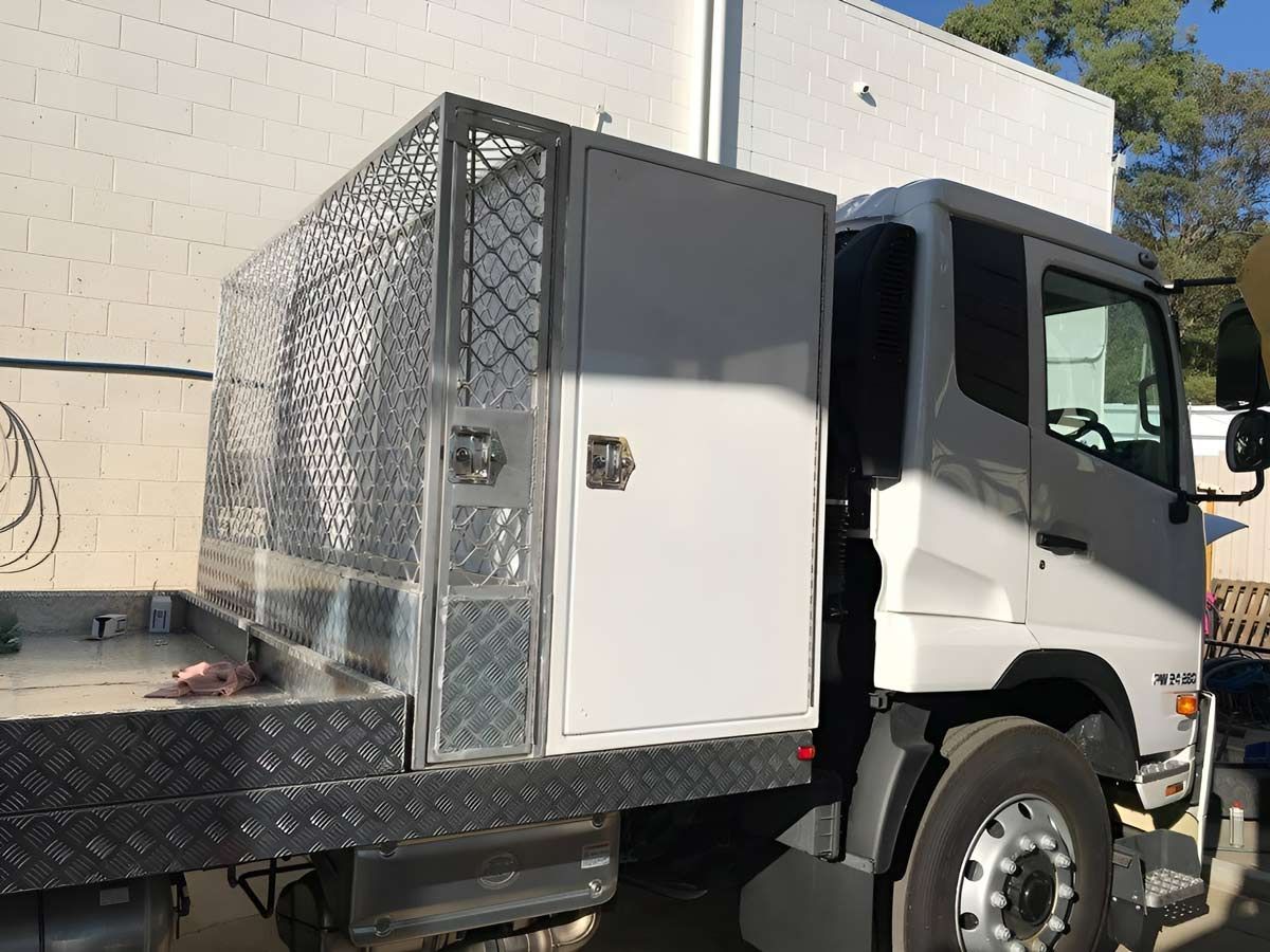 A White Truck With A Metal Cage Box On The Back — Brumb's Welding & Fabrication in Biggera Waters, QLD