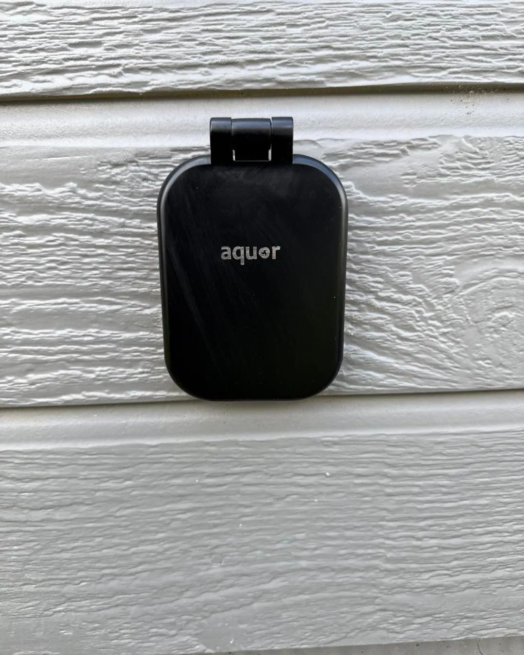 Black electrical outlet cover labeled 