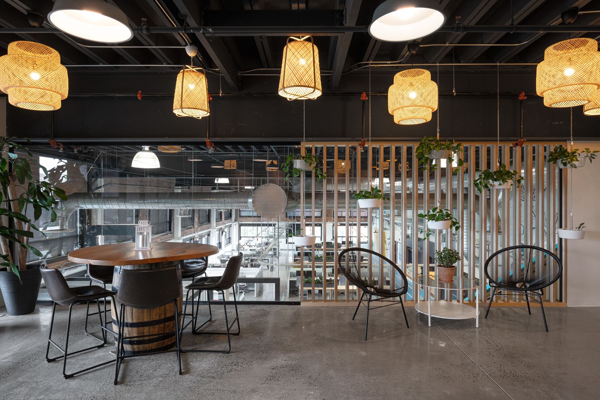 Intérieur moderne avec table ronde et chaises, suspensions lumineuses et paravents décoratifs.