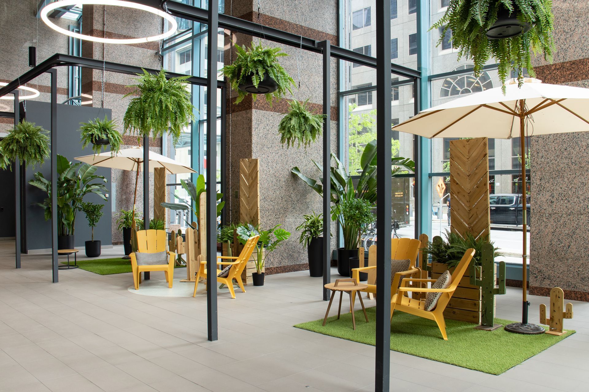 Un espace lounge intérieur avec des sièges, des plantes, des parasols et des guirlandes lumineuses.