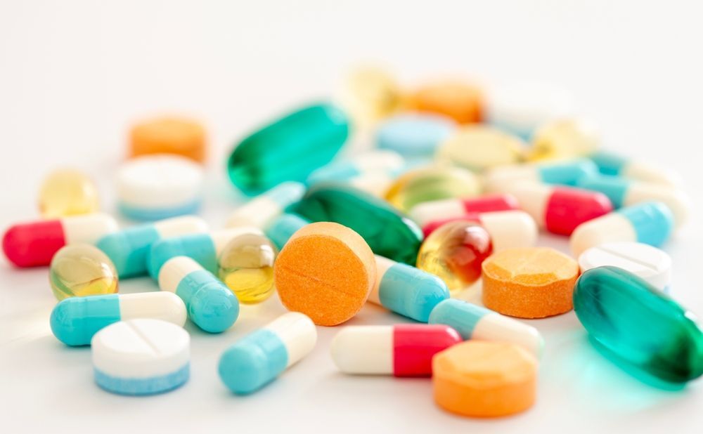 A pile of colorful pills and capsules on a white surface
