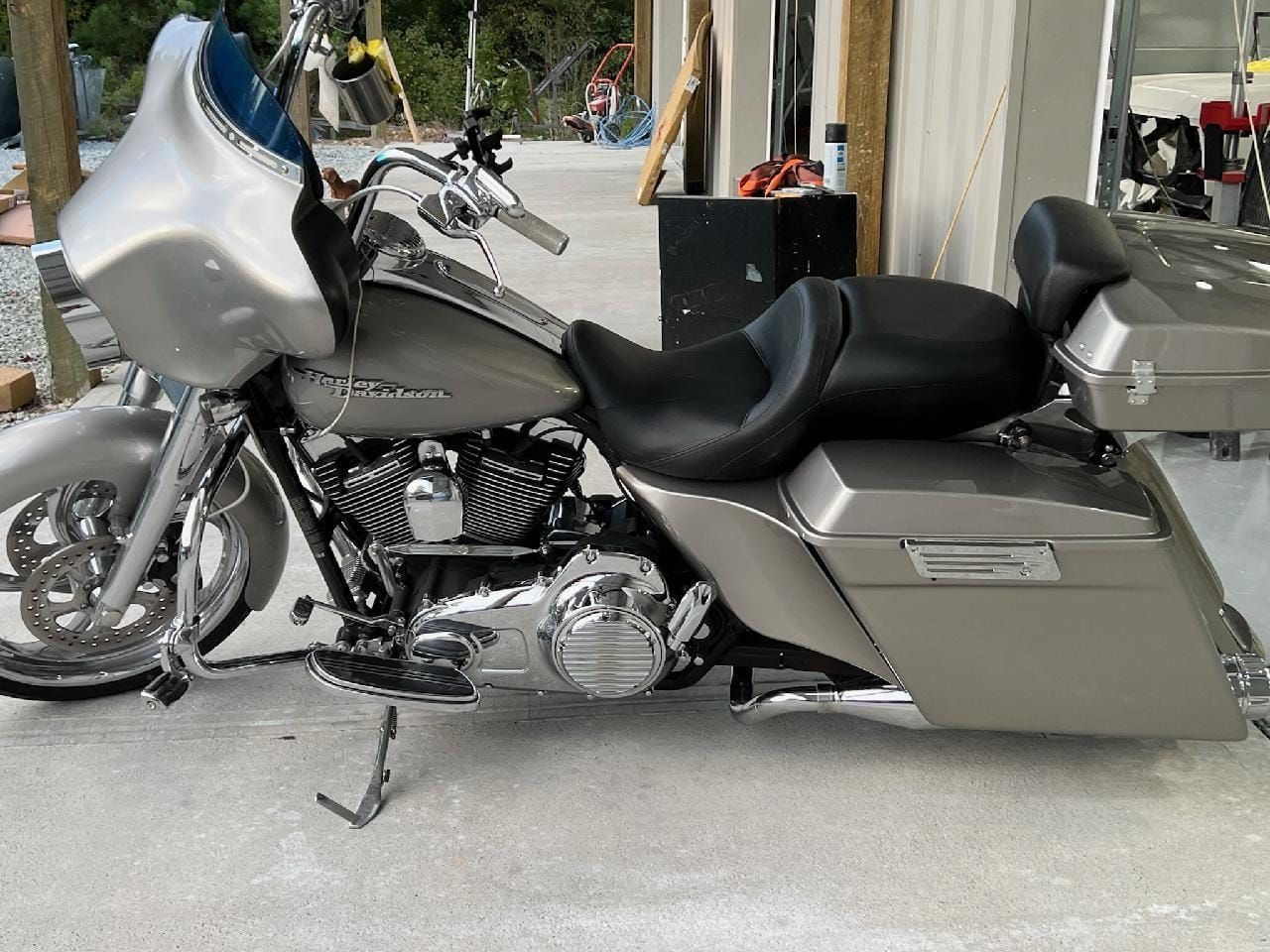Silver touring motorcycle parked outdoors with a large windshield and hard saddlebags
