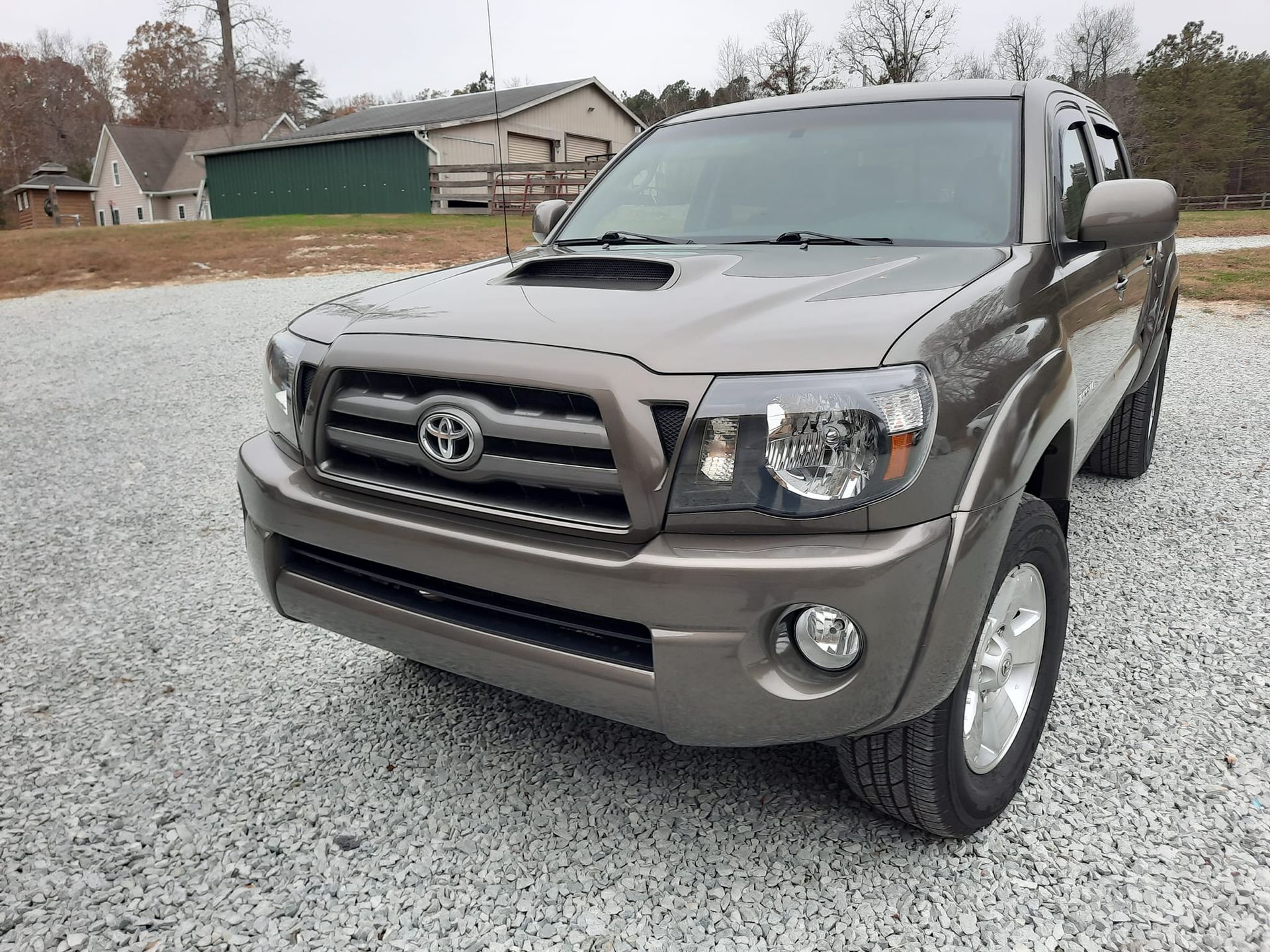 Brown Toyota pickup parked on a snowy residential street under overcast skies