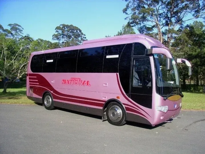 A Pink Bus Parked in a Parking Lot — Wests National Coaches In Chevallum, QLD