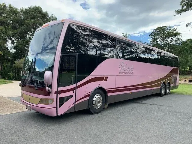 A Pink Bus is Parked on the Side of the Road — Wests National Coaches In Chevallum, QLD