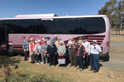 Social club group posing beside a hired coach on the Sunshine Coast.