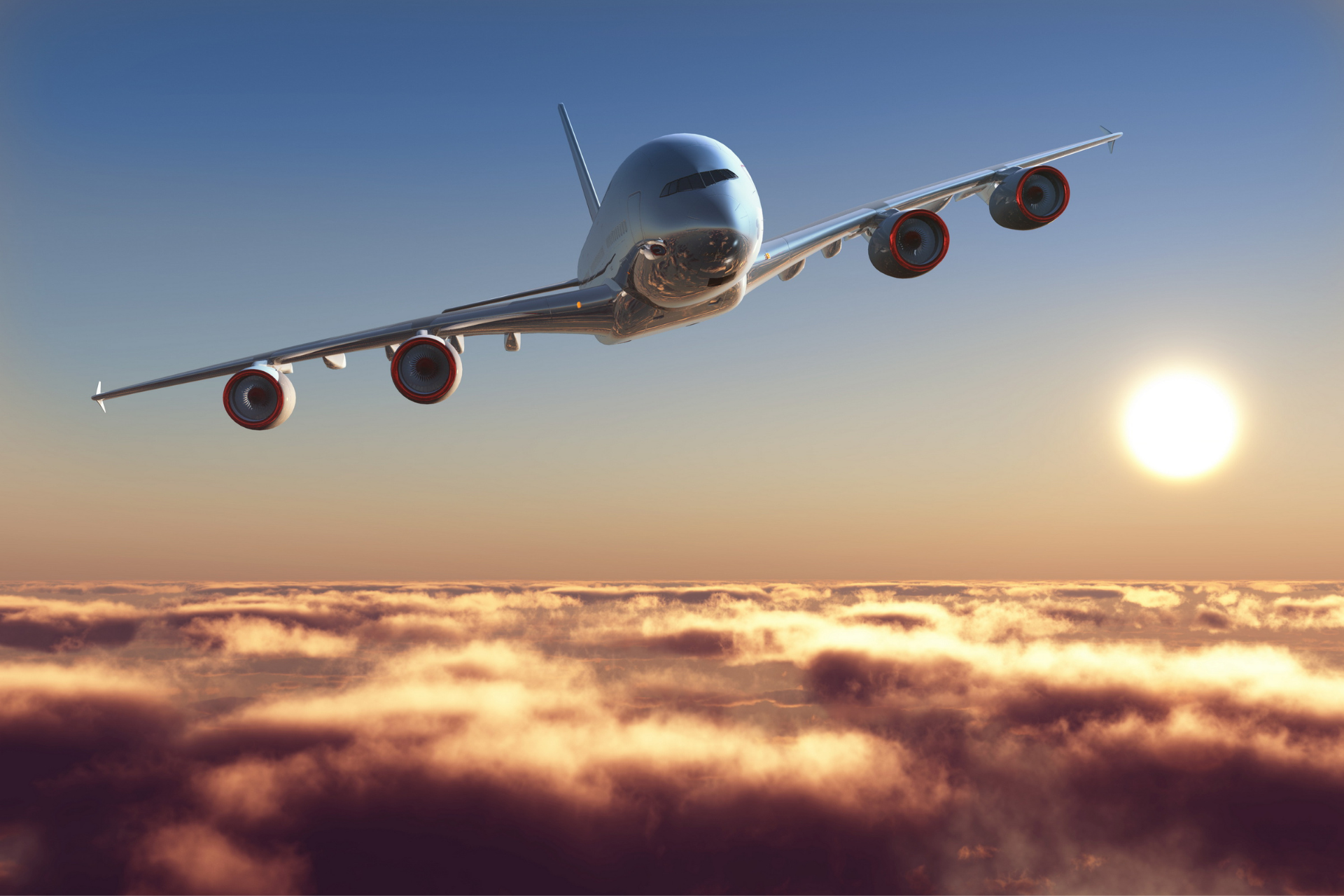 Um grande jato de passageiros voa sobre as nuvens ao pôr do sol.