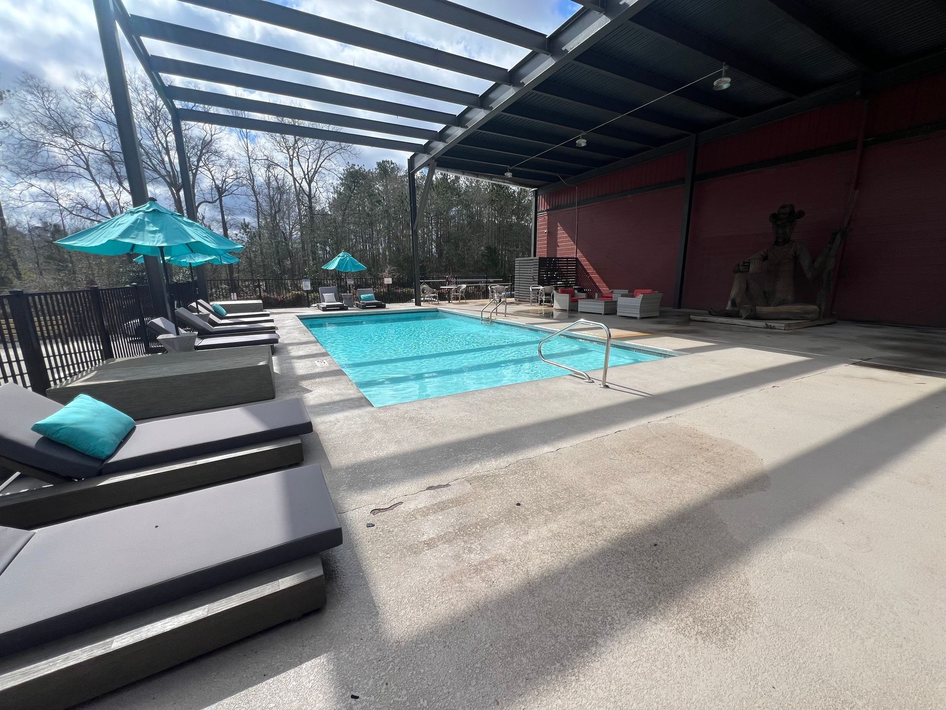 a large swimming pool surrounded by chairs and umbrellas .