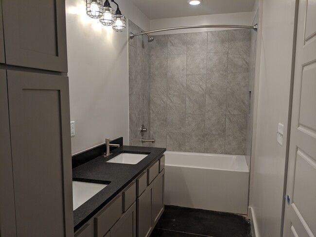 a bathroom with two sinks and a bathtub .
