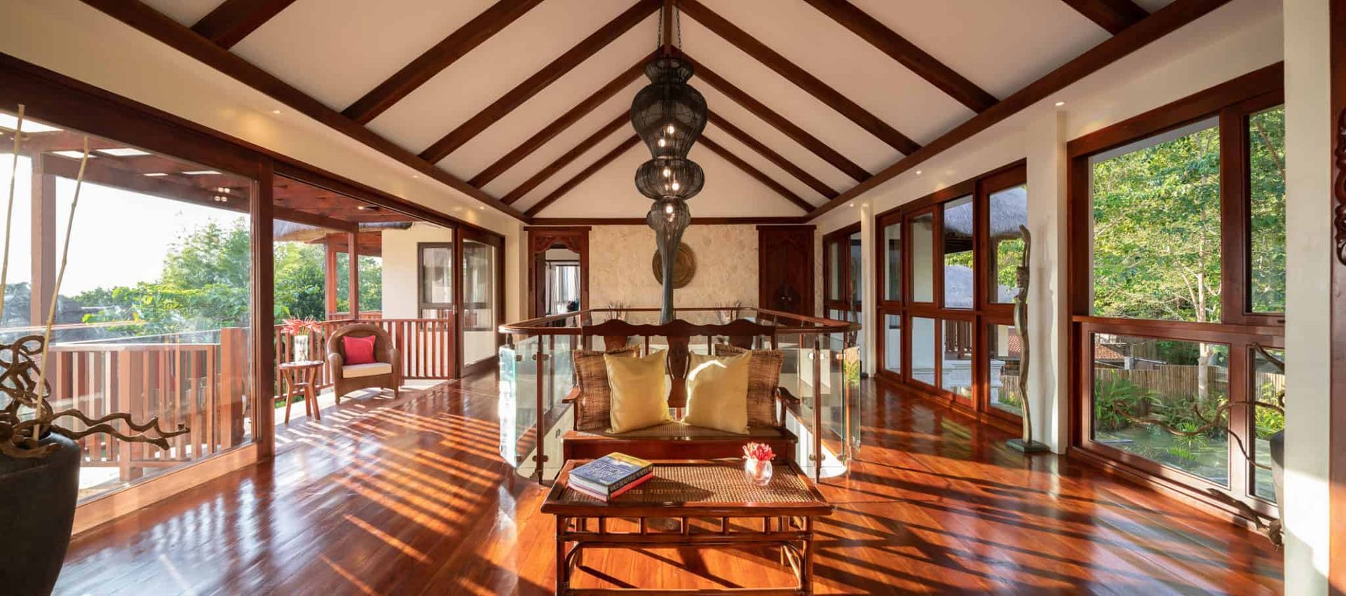 Wooden interior with a vaulted ceiling, large windows, and a sitting area.