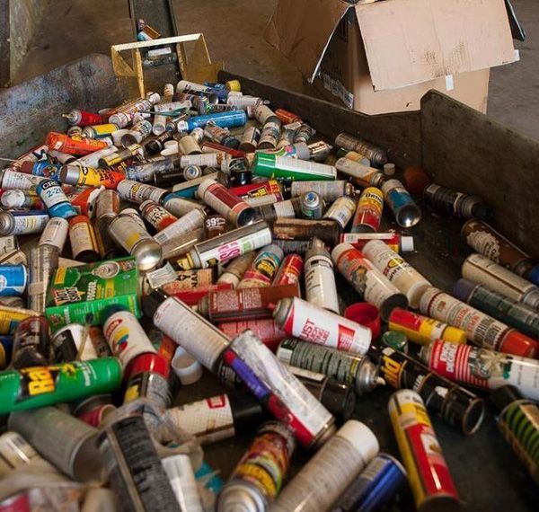 Un tas de bombes de peinture sont posées sur le sol