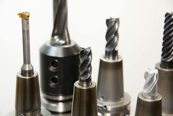 Assorted metal milling and drill bits standing upright on a white background