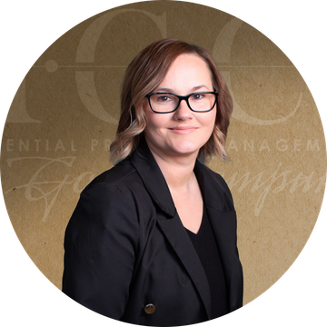Woman in a black blazer and glasses, smiling, set against a brown background with text.