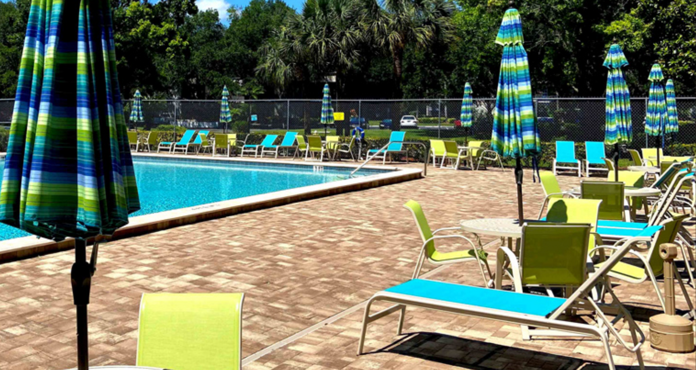 there are many chairs and umbrellas around the pool